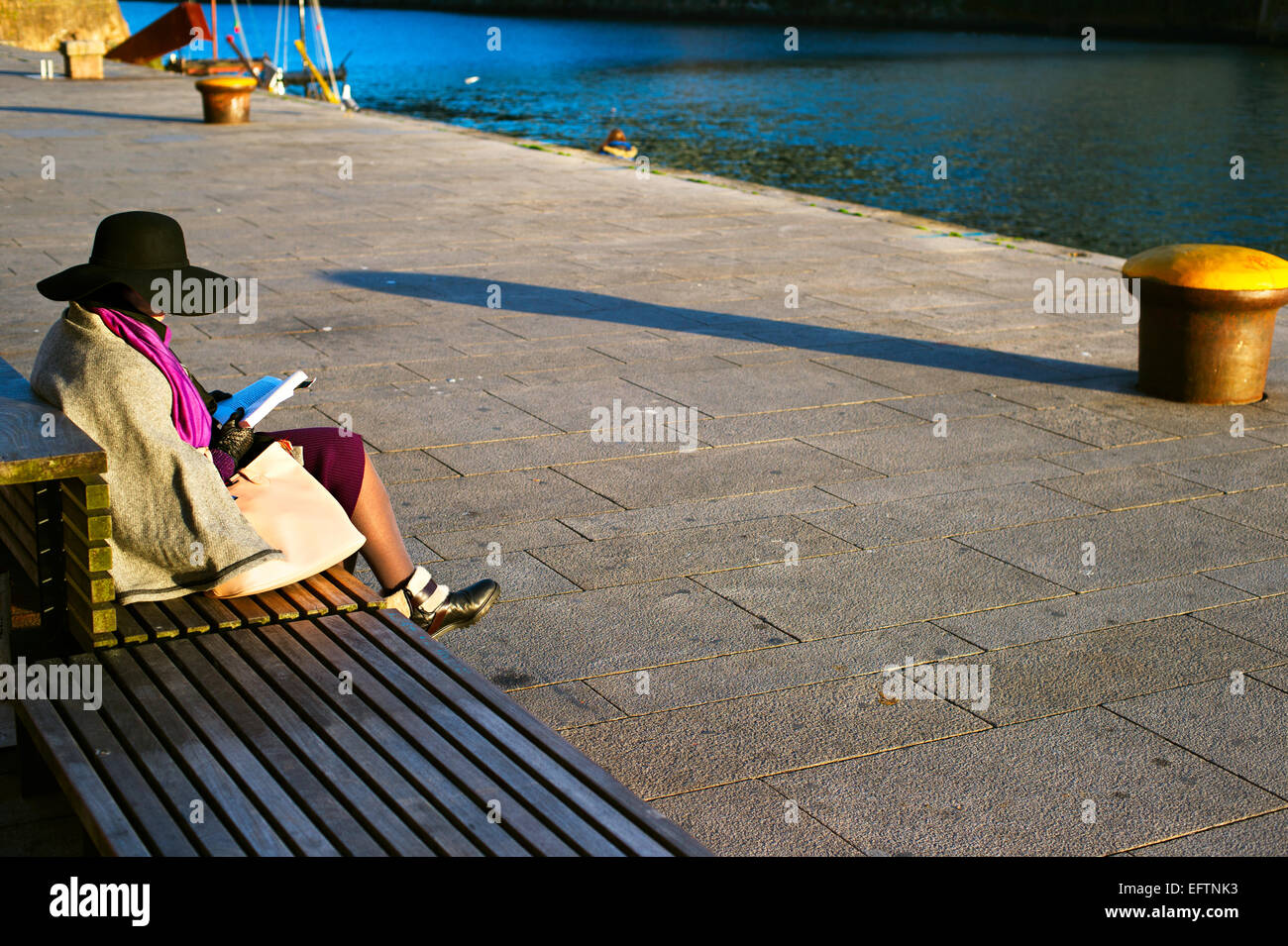 Femme lisant un livre sur l'audience à Porto remblai. Portugal Banque D'Images
