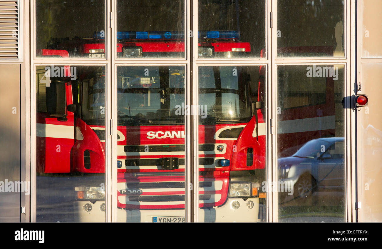 Camion de pompiers Scania derrière des portes vitrées au garage de la caserne de pompiers , Finlande Banque D'Images