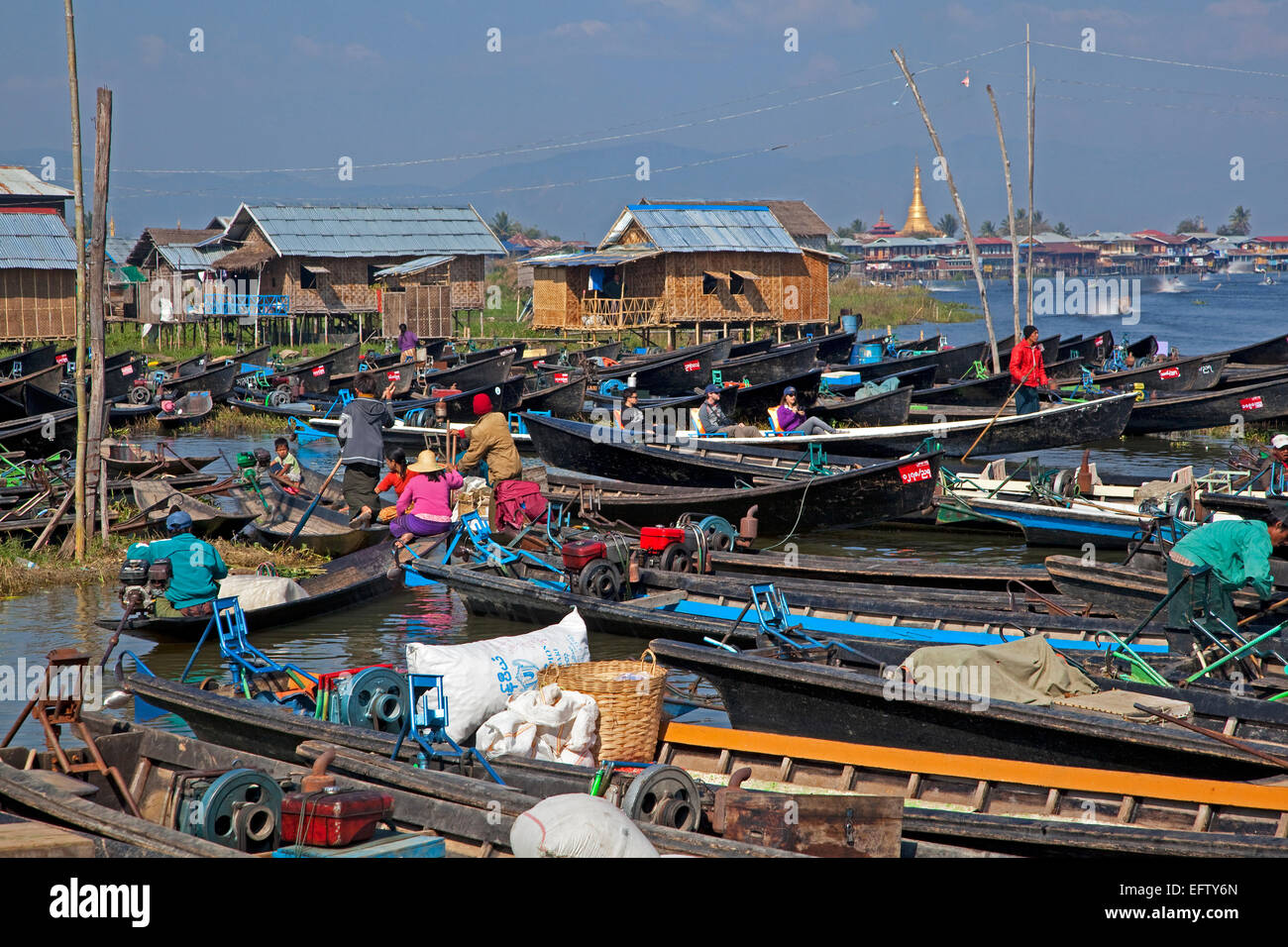 Des embarcations ouvertes à lakeside village avec des maisons traditionnelles en bois sur pilotis au Lac Inle, Nyaungshwe, Shan State, Myanmar / Birmanie Banque D'Images