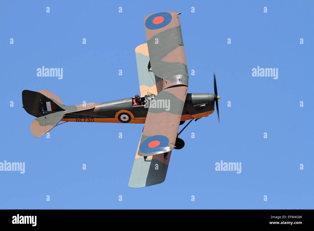 De Havilland Tiger Moth avion biplan d'époque aux couleurs d'un avion d'entraînement de la Royal Air Force de la Seconde Guerre mondiale qui vole dans les airs contre un ciel bleu Banque D'Images