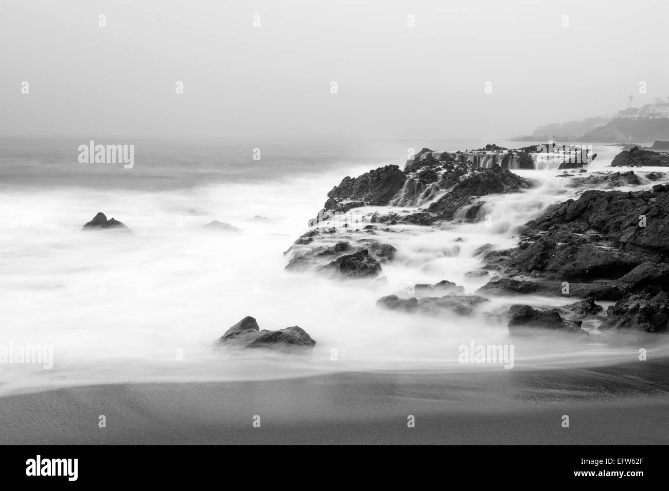 Un matin tôt le mouvement lent des images de l'eau de mer se précipiter sur des récifs du littoral accidenté, à Laguna Beach, Californie. Banque D'Images