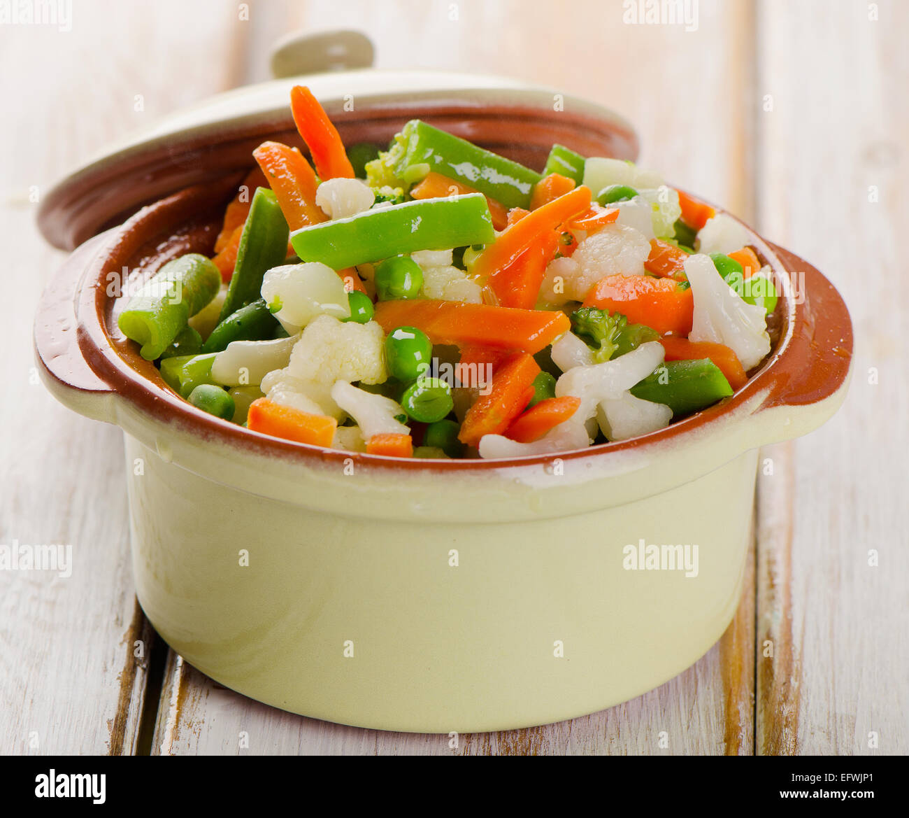 Dans un mélange de légumes bol vert sur une table en bois Banque D'Images