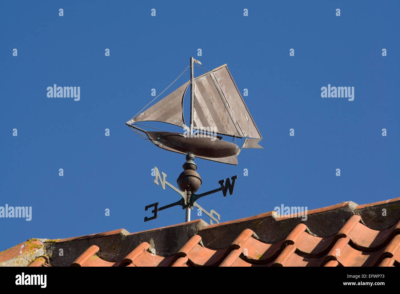 Petit bateau à voile comme une girouette contre le ciel bleu Banque D'Images