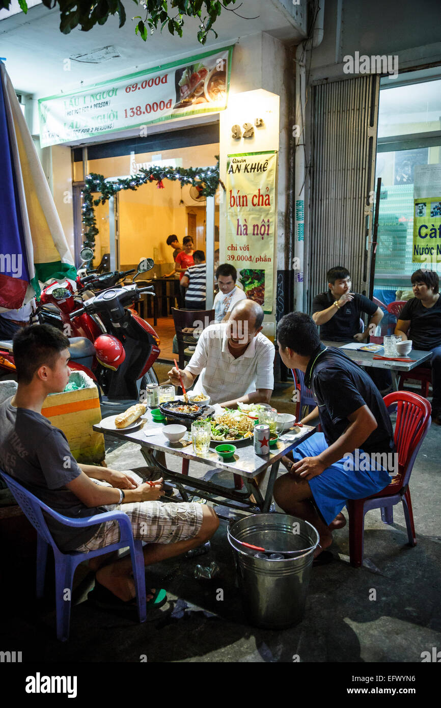 Les gens assis à un restaurant en plein air, Ho Chi Minh Ville (Saigon), Vietnam. Banque D'Images