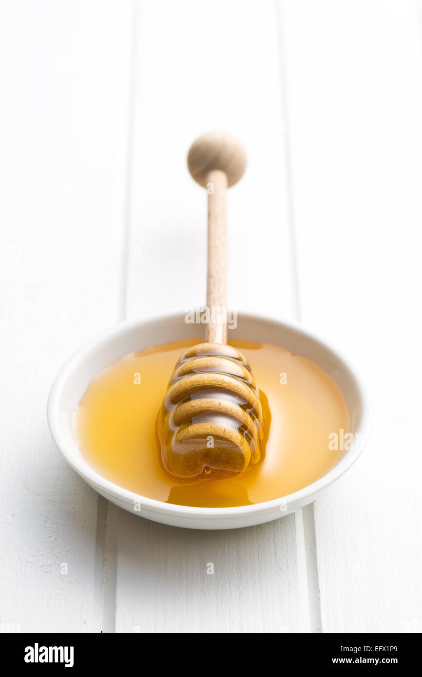 Le balancier du miel dans un bol Banque D'Images