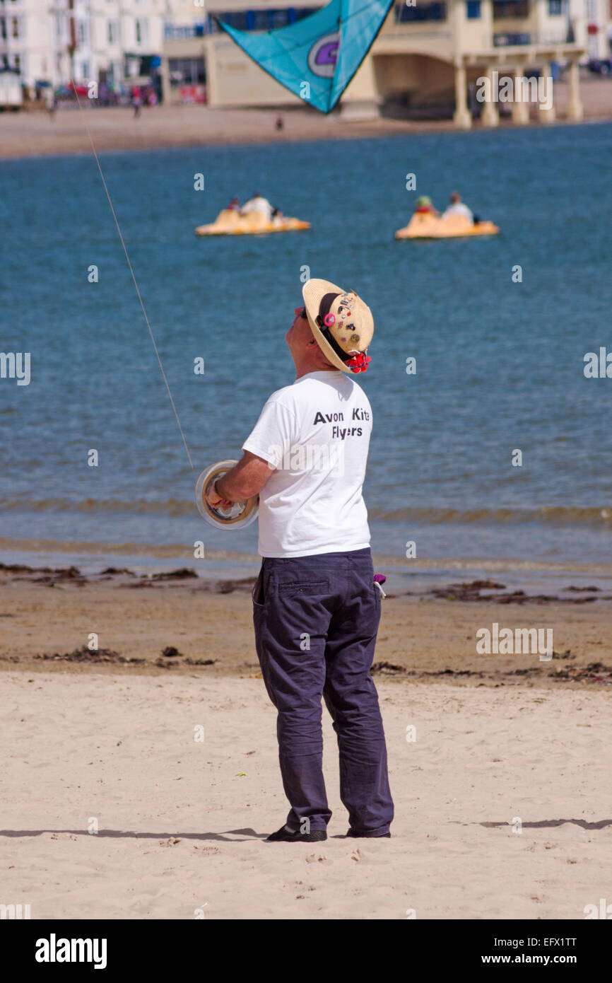 Homme volant cerf-volant au Weymouth Kite Festival, Dorset, Royaume-Uni, en mai Banque D'Images