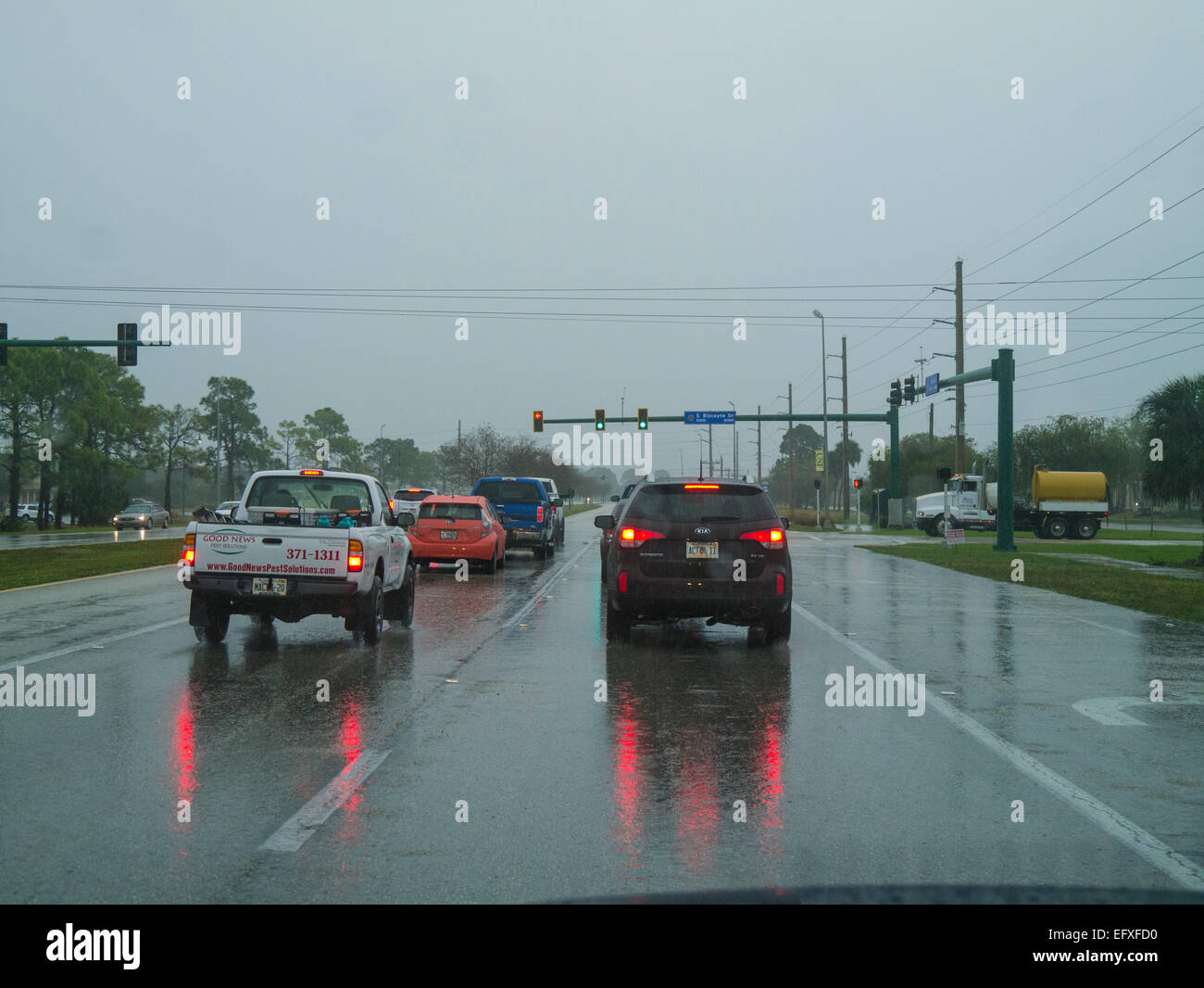 L'arrêt de la circulation au feu de circulation sur un jour nuageux pluvieux Banque D'Images