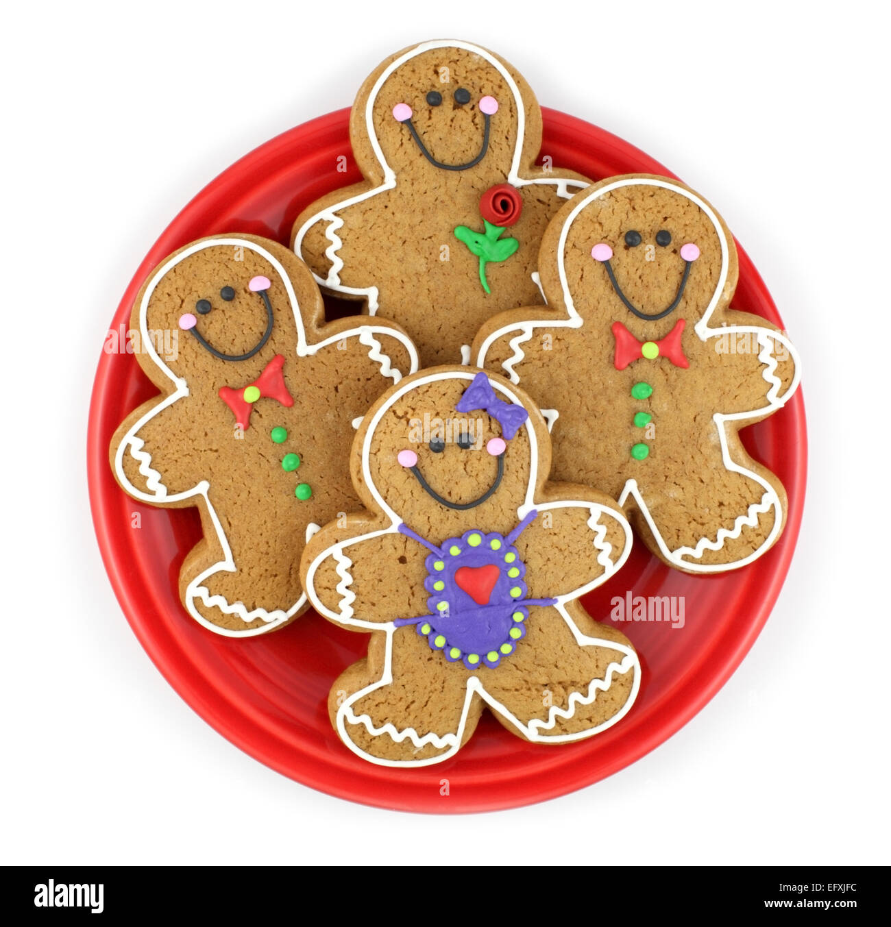 Un groupe d'hommes de pain d'épice cookies isolé sur une plaque rouge. Banque D'Images