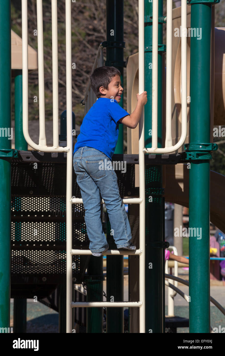 Les hispaniques jeune garçon à jouer climbing ladder sur terrain de Pioneer Park dans la ville de Novato, Californie Banque D'Images