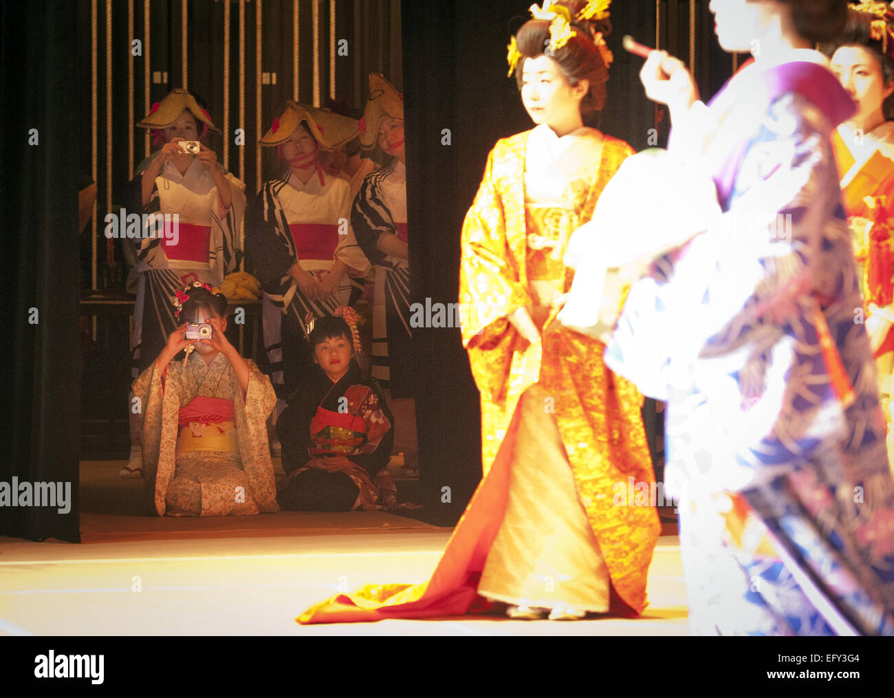 Irvine, Californie, USA. Feb 8, 2015. La célébration de l'art et la mode du kimono traditionnel japonais Kimono et vinaigrette, Irvine Valley College a accueilli le Festival de bénéficier d'un Kimono d'entraînement de fonds le dimanche 8 février 2015. Les artistes venus de l'Osaka Nihon Waso Gakuen Vinaigrette Kimono Academy, est sorti en quatre actes, un pour chaque saison, des kimonos de modélisation pour toutes les utilisations y compris le travail, mariage, célébrations et occasionnels. La vente des billets, le long d'une vente aux enchères sera bénéfique pour le victimes de la 2011 Séisme et tsunami au Japon. Deux jeunes interprètes de regarder juste à côté de la scène pendant un dimanche ev Banque D'Images