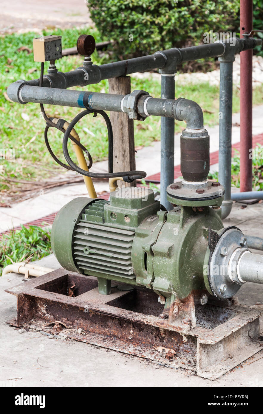 Ancienne pompe à eau derrière la petite usine. Banque D'Images