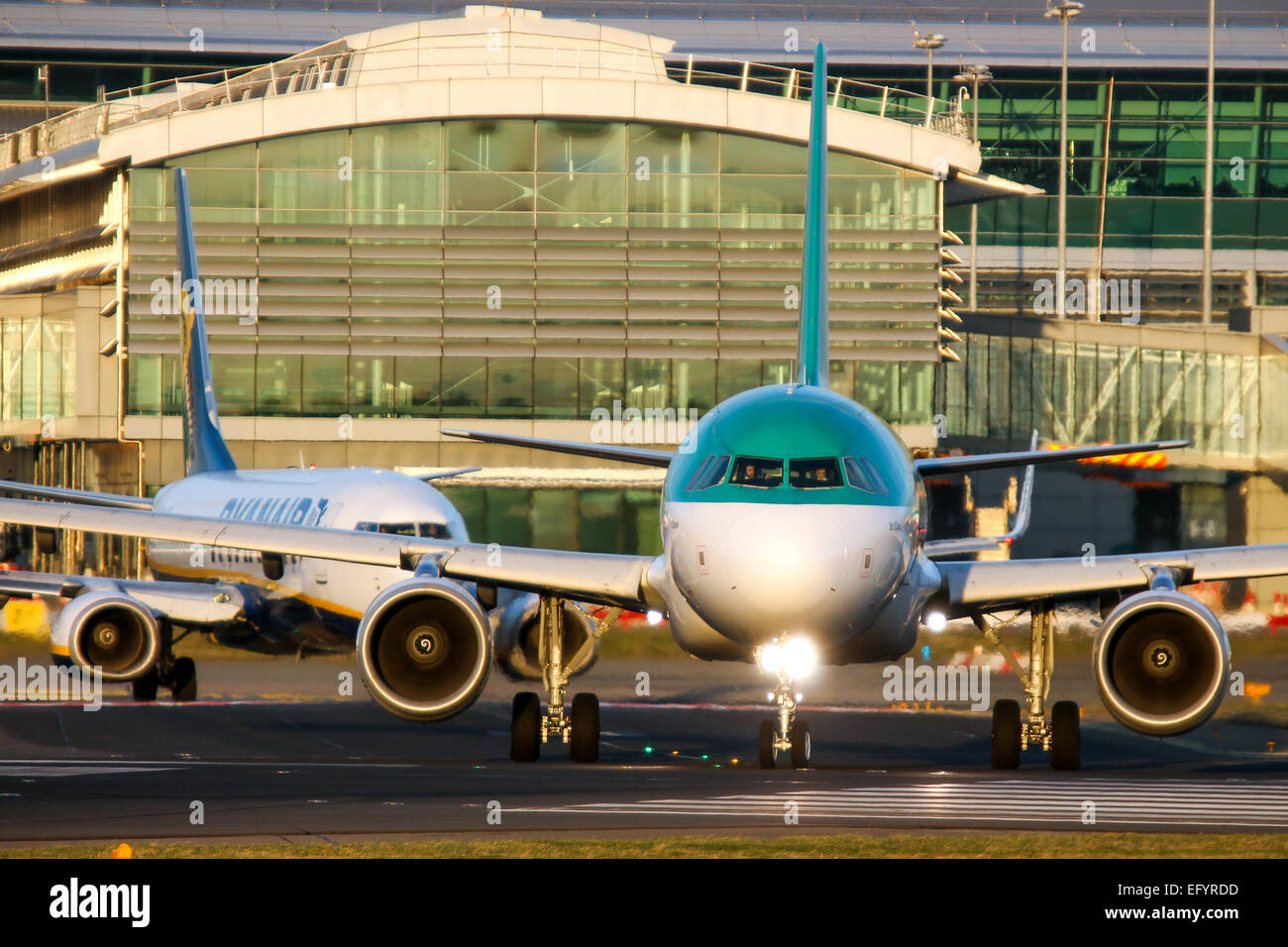 Aer Lingus Airbus A320 Les taxis sur la piste 28 à l'aéroport de Dublin, comme Ryanair Boeing 737-800 suit. Banque D'Images