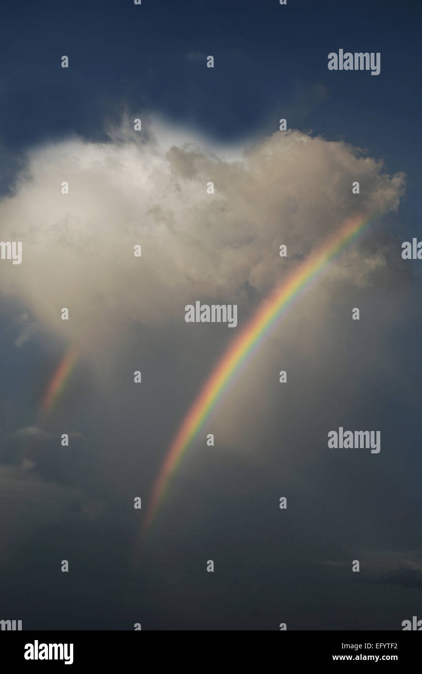 Double arc-en-ciel émerge d'un nuage en forme de cœur Banque D'Images