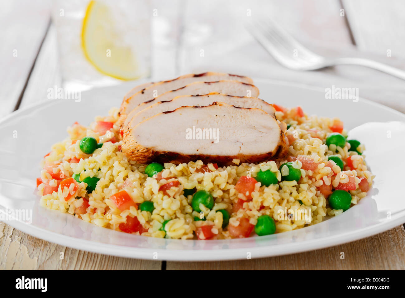 Couscous aux pois verts et filet de poulet grill Banque D'Images