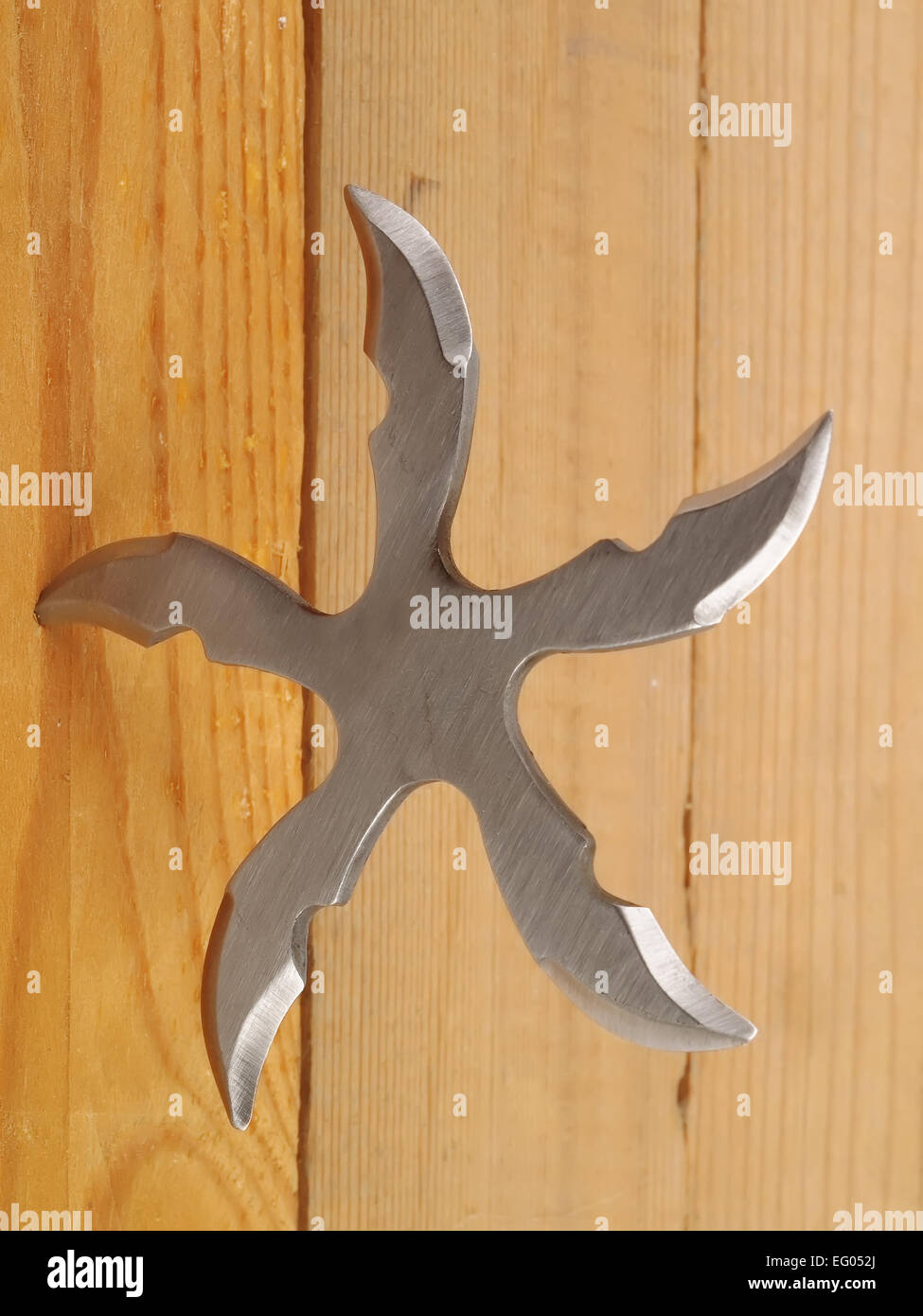 Lame de ninja Shuriken lancer star en planche de bois, studio shot Banque D'Images