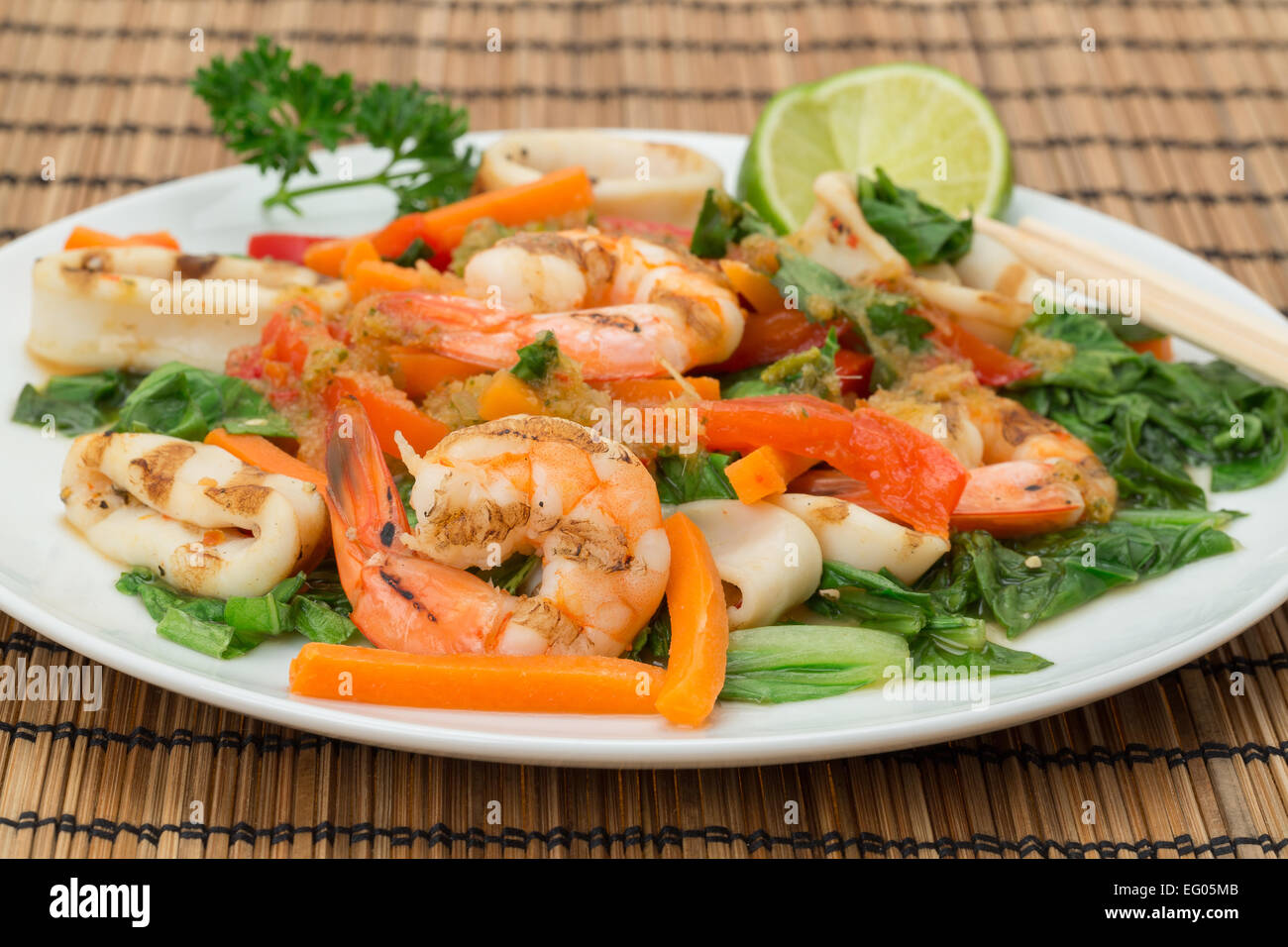 La cuisine vietnamienne - Assiette de calamars cuits au feu et langoustines avec des lamelles de carottes, poivrons rouges, et pak choi Banque D'Images