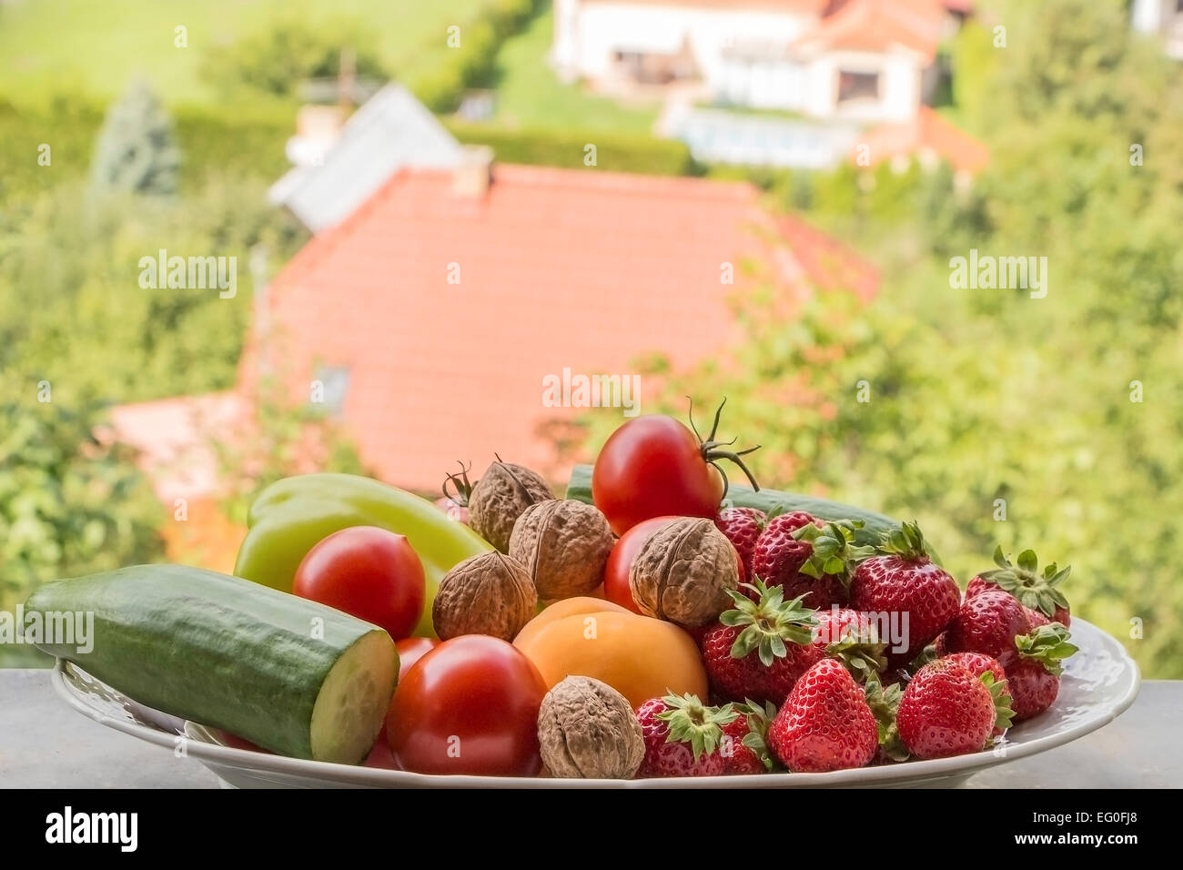 Quelques fruits et légumes disposés sur un bol en été, piscine. Banque D'Images