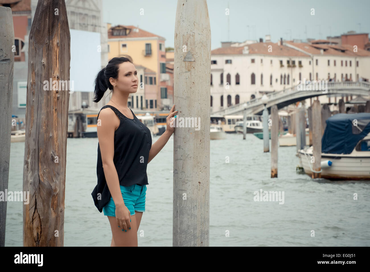 Femme debout près d'un canal, Venise, Italie Banque D'Images