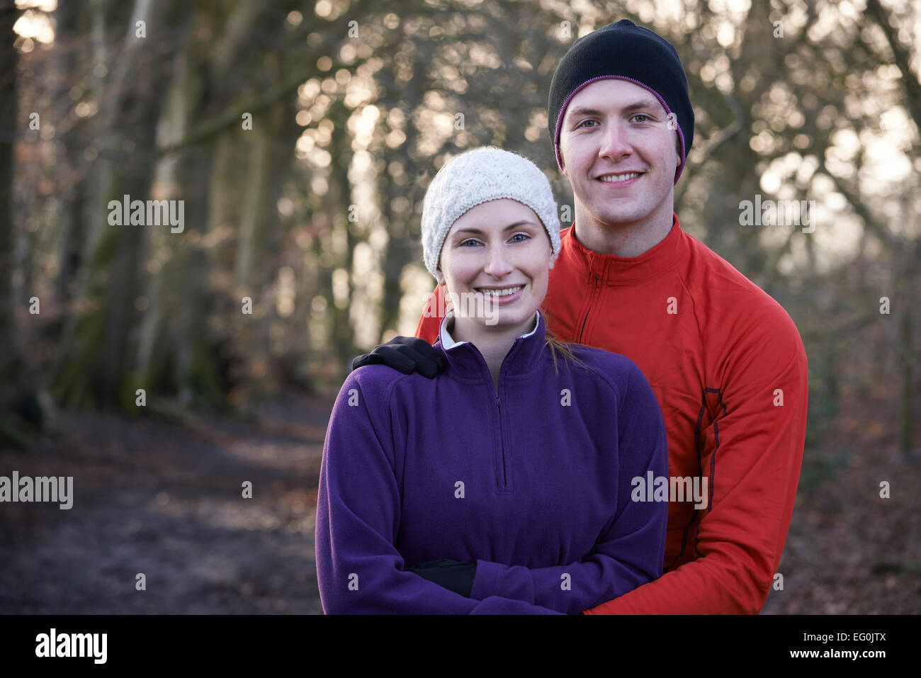 Portrait de Couple On Winter Run entre forêt Banque D'Images