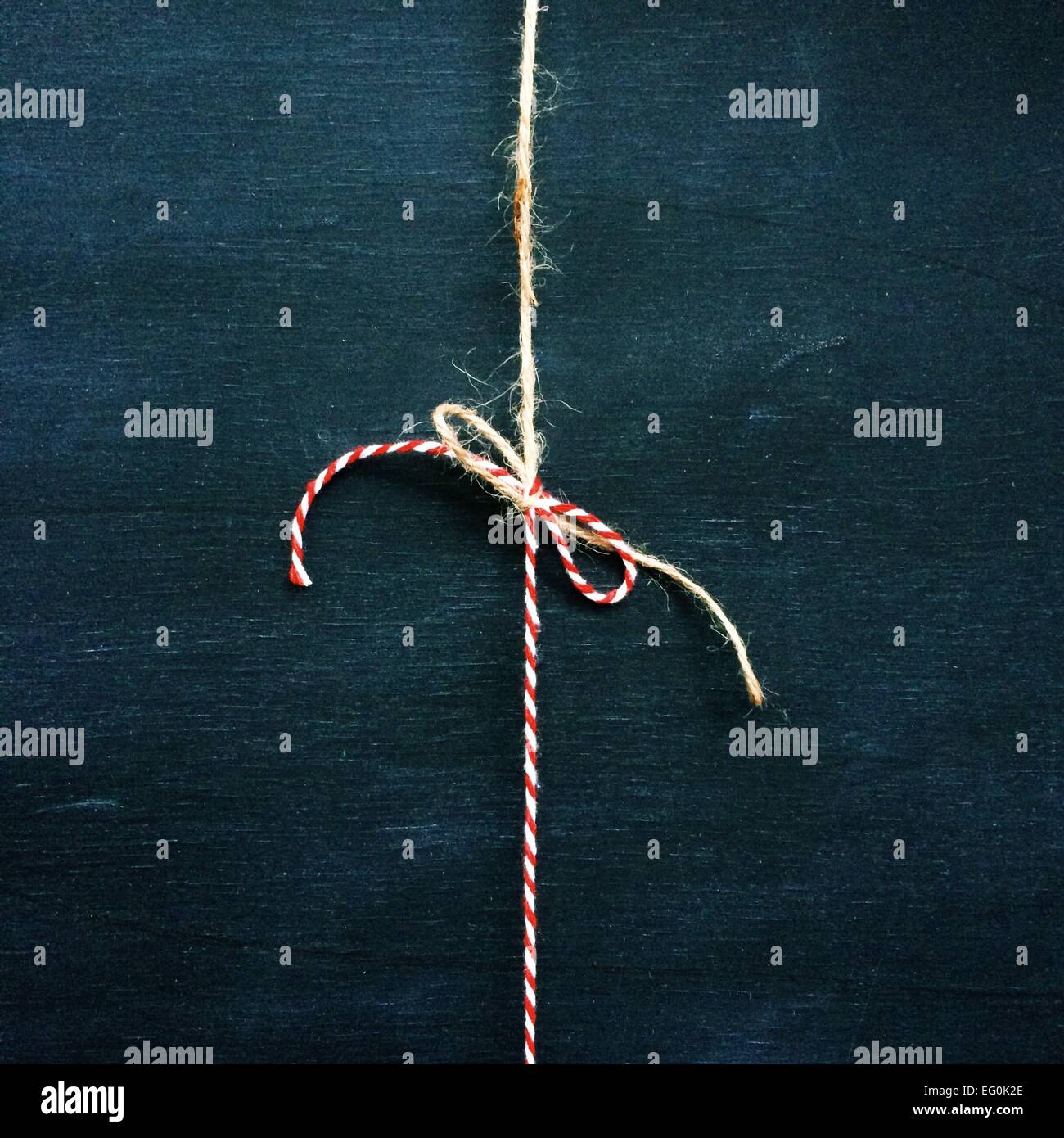 String rouge et blanc attachés en un arc avec brown string Banque D'Images