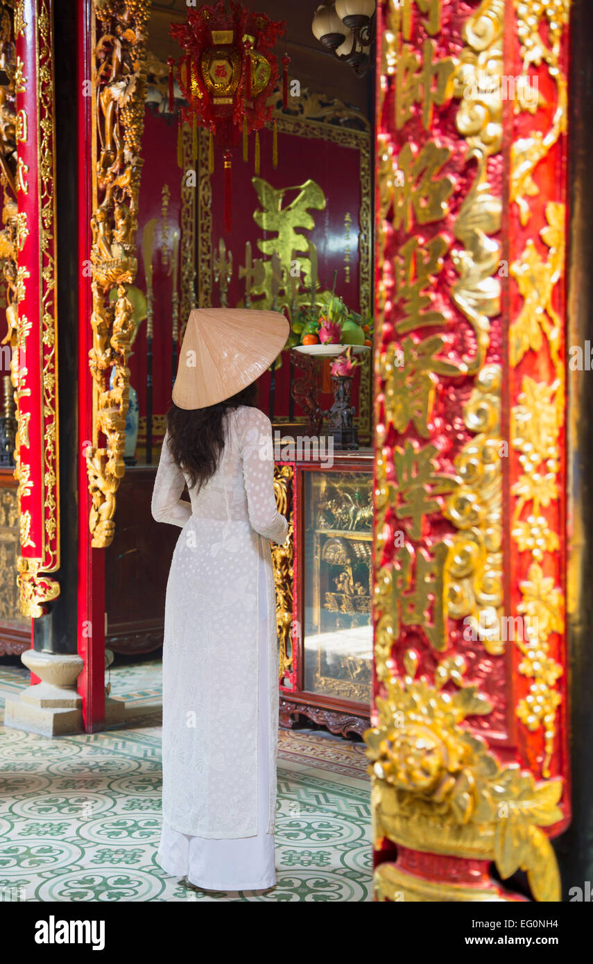 Ao dai femme portant une robe à Phuoc Hoi Quan Pagode, Cholon, Ho Chi Minh City, Vietnam Banque D'Images