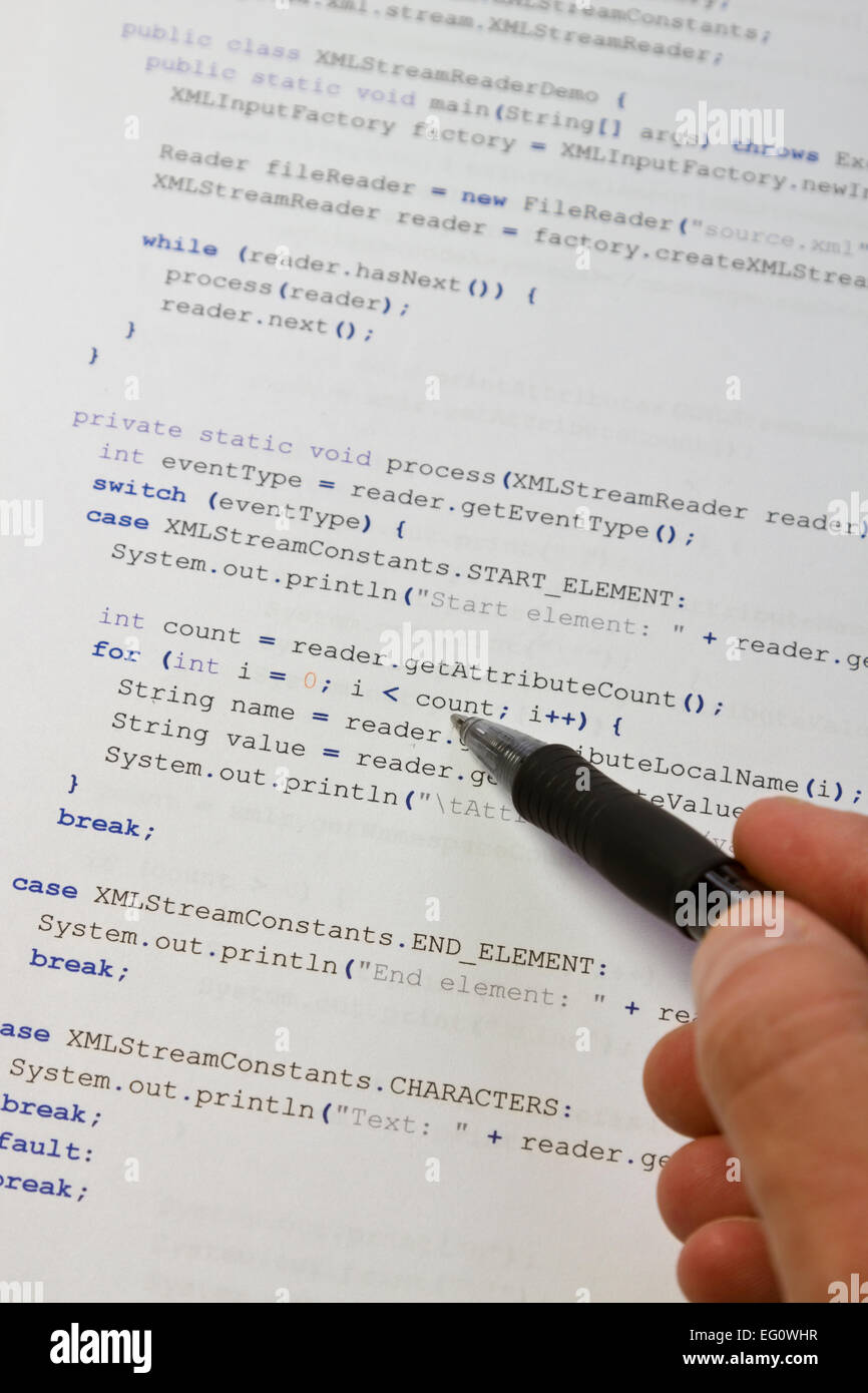 Un programmeur / homme pointant avec son stylo au code Java. Logiciels / programme d'application du code. Analyseur XML. Banque D'Images