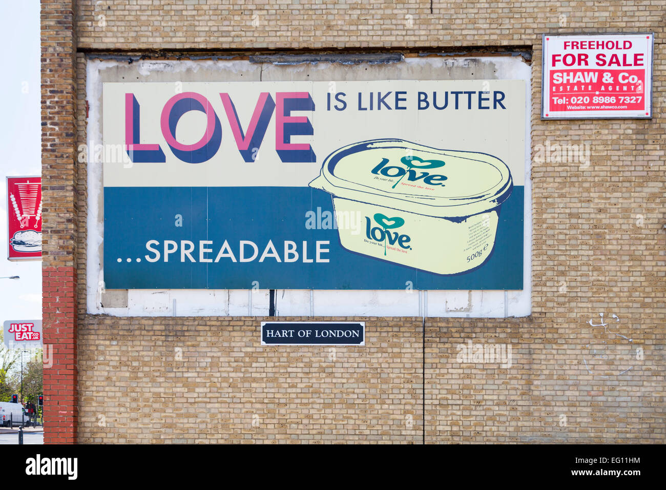 Billboard "l'amour est comme du beurre à tartiner...message' par Hart of London,sur un mur dans le peuplier, Londres Banque D'Images