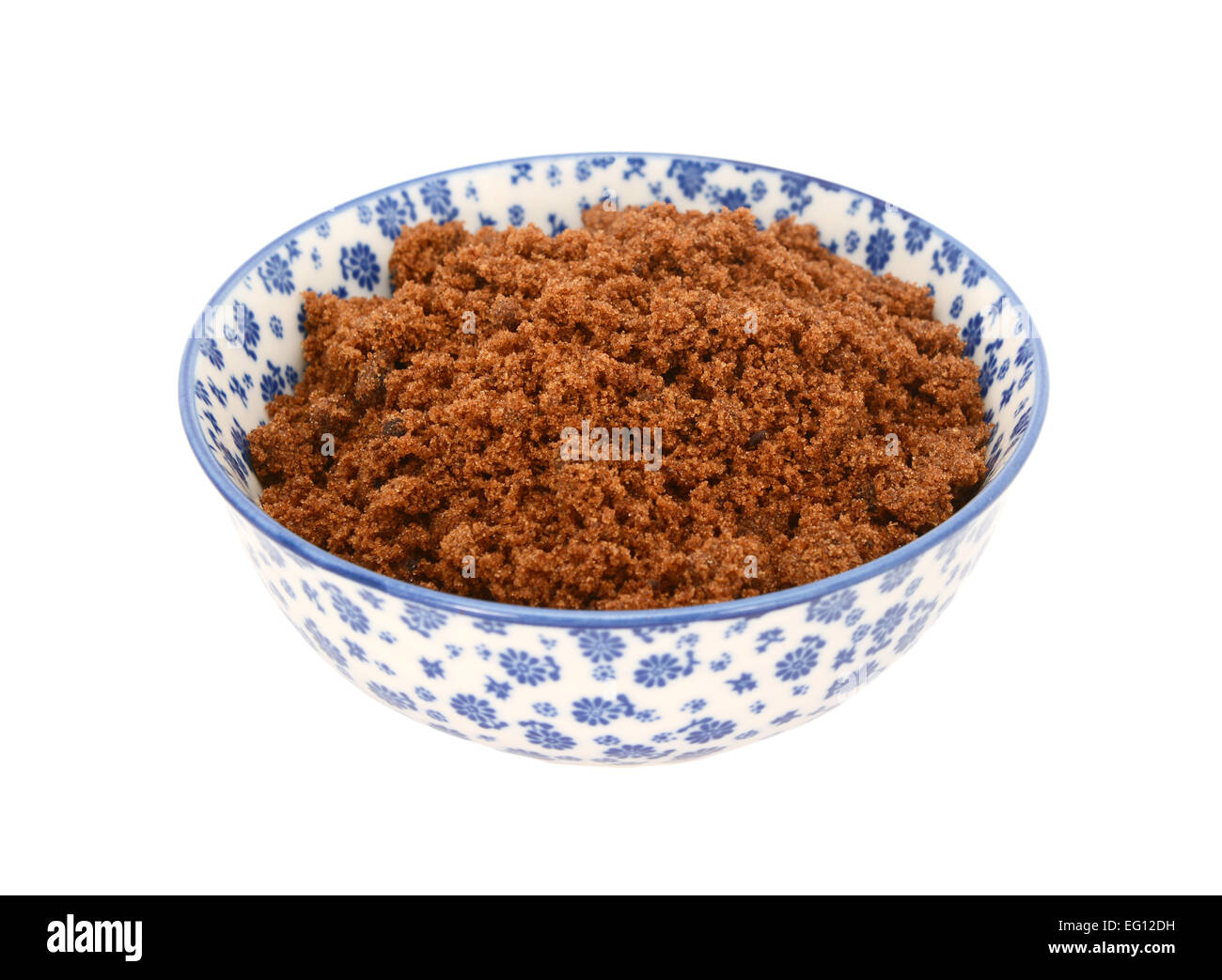 Dark brown soft / sucre muscovado dans un bol en porcelaine bleu et blanc avec un design floral, isolé sur fond blanc Banque D'Images
