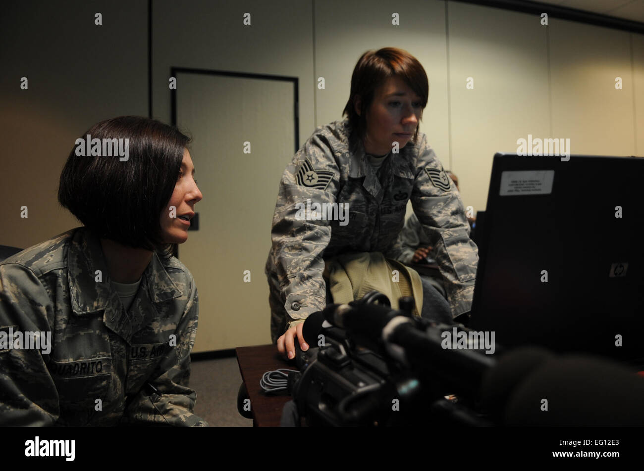 Le Sgt technique. Adrienne Brammer et Giovanna Squadrito, 1er escadron de la Caméra de combat, discute de leur documentation vidéo des avions C-17 de la Base aérienne de Charleston, S.C., le 16 décembre 2009. Les avions C-17 a effectué un exercice de brigade stratégique airdrop sur l'Amérique du Nord près de l'aérodrome auxiliaire, S.C., 16 décembre 2009, démontrant la projection mondiale de la puissance aérienne des États-Unis. Les soldats de la 2-319ème Airborne Field Artillery, 82e Division aéroportée, Ft. Bragg, N.C., ont été abandonnées de l'air dans l'exercice ainsi que des palettes de fret pour simuler la saisie d'un aérodrome isolé, offrant Banque D'Images