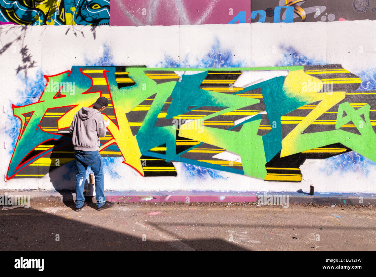 Artiste de rue au travail à 'Le Tunnel', une zone graffiti autorisé à Leake Street près de la gare de Waterloo à Londres Banque D'Images