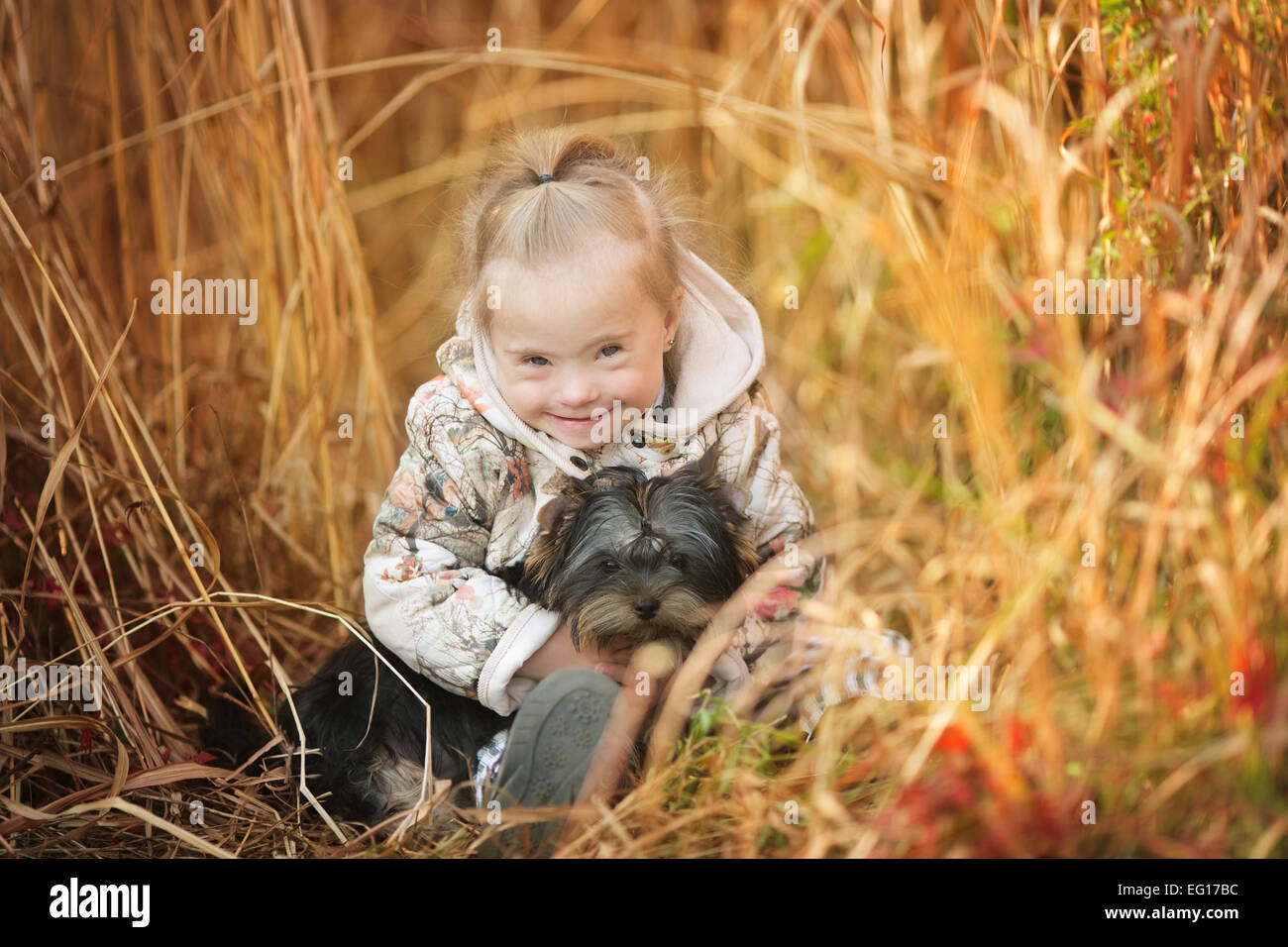 Belle fille avec le syndrome de hugs chiot Banque D'Images