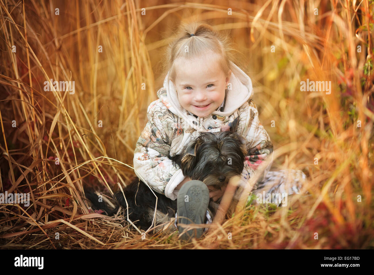 Belle fille avec le syndrome de hugs chiot Banque D'Images