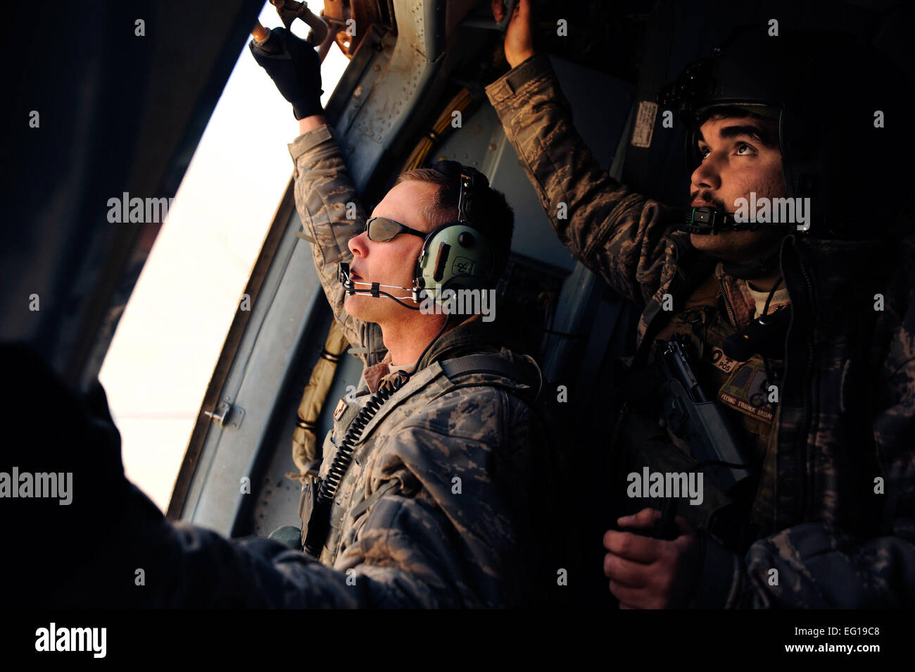 U.S. Air Force Tech. Le Sgt. Kevin Kontz à partir de la 838ème Groupe consultatif expéditionnaire de la Force aérienne des États-Unis et le s.. À partir de la 444e Justin Shults consultatif expéditionnaire de la numérisation de l'escadron la région à bord d'un hélicoptère Mi-17 comme il se prépare pour l'atterrissage lors d'une mission près de la Base aérienne de Shindand, l'Afghanistan, Jan 17, 2011. Le s.. Eric Harris Banque D'Images