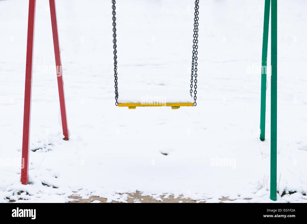 Swing dans la neige sur l'aire de jeux Banque D'Images