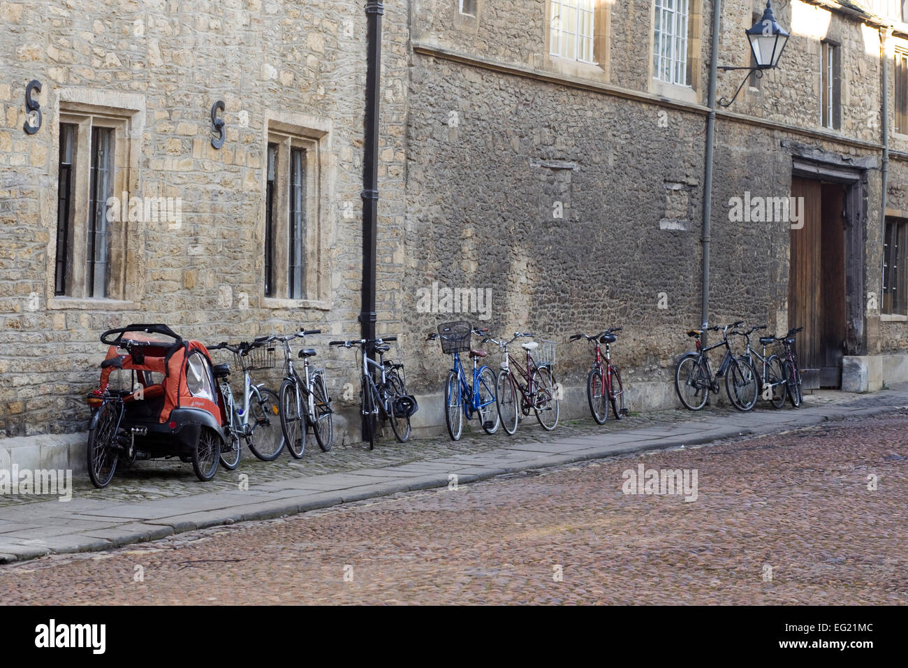 Les vélos appuyé contre un mur de briques en ruine sur une chaussée de pierre dans la région de Oxford Banque D'Images