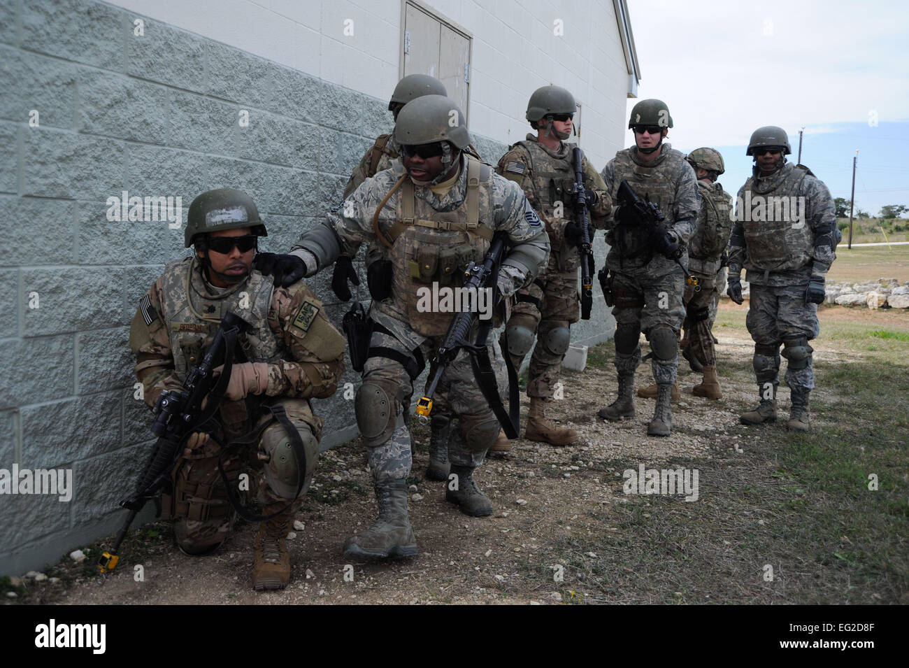 Les étudiants de la formation des compétences de combat aviateurs se cacher derrière un bâtiment au cours d'un exercice d'opérations urbaines à Joint Base San Antonio-Camp Bullis, Texas, le 14 novembre 2013. CAST est un cours conçu par l'éducation et de la formation de l'Air commande pour normaliser la formation de combat pré-déploiement pour les membres de la Force aérienne. Un membre de la 1re classe David R. Cooper Banque D'Images