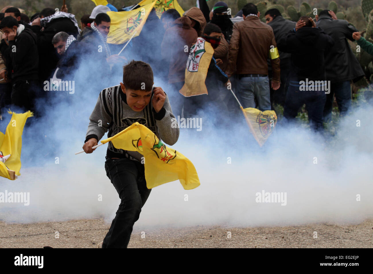 Qalqilya en Cisjordanie, territoire palestinien. Feb 14, 2015. Des manifestants palestiniens fuient les gaz lacrymogènes tirés par la police des frontières israéliennes au cours d'affrontements à la suite d'une protestation contre la fermeture de la route du village, dans le village d'Azzun près de Qalqilya, 14 février 2015 © Nedal Eshtayah/APA/Images/fil ZUMA Alamy Live News Banque D'Images