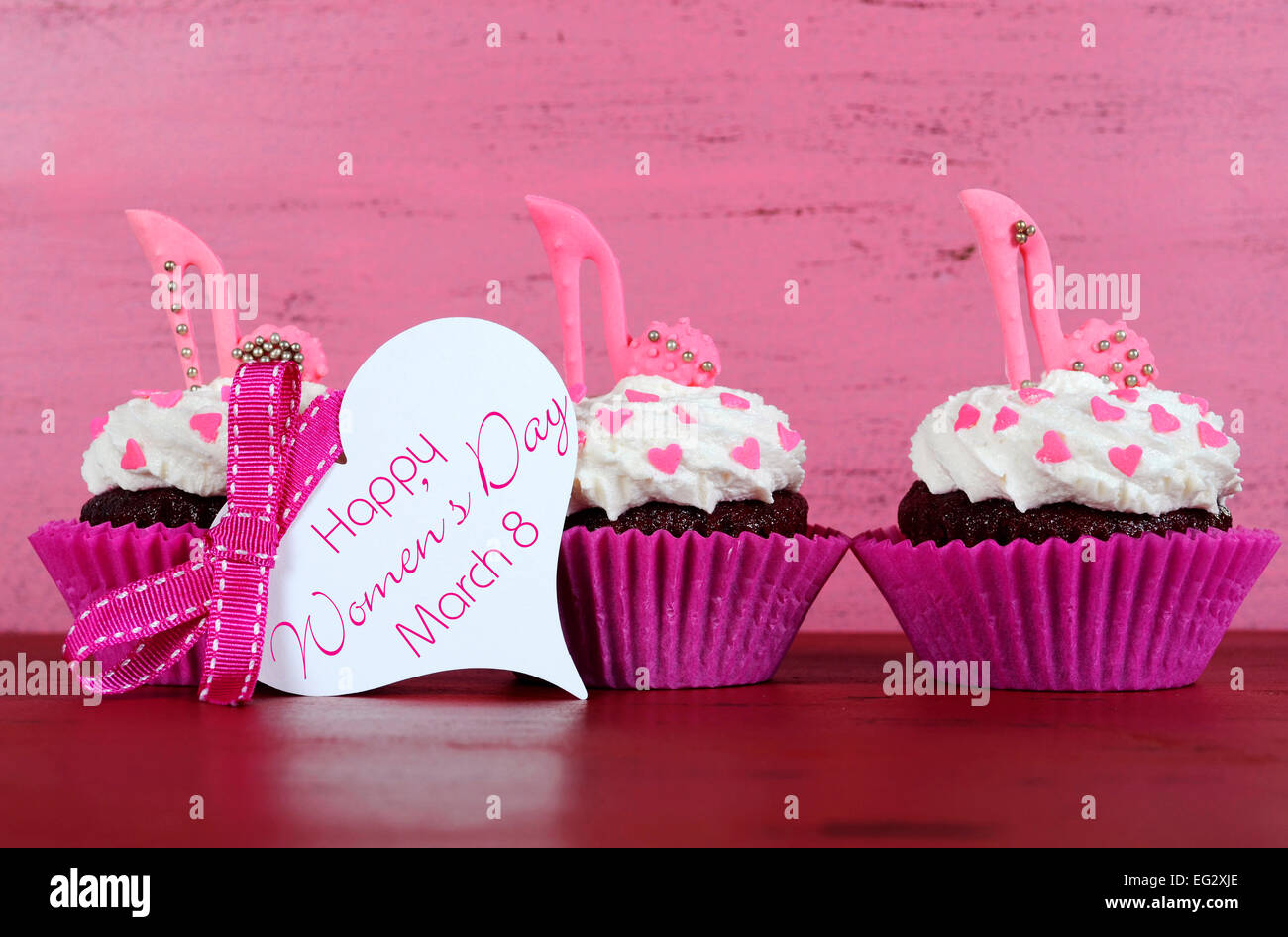 La Journée internationale des femmes, le 8 mars, cupcakes avec talon haut stiletto chaussures fondant sur fond de bois rose vintage Banque D'Images