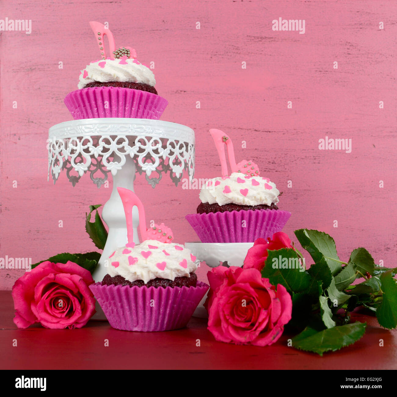 Cupcakes avec talon haut stiletto chaussures fondant sur fond de bois rose vintage, on cake stands. Banque D'Images