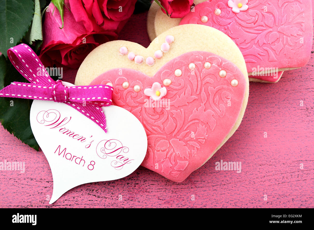 La Journée internationale des femmes, le 8 mars, les cookies en forme de coeur décorée en rose chers robes avec bouquet de roses roses Banque D'Images