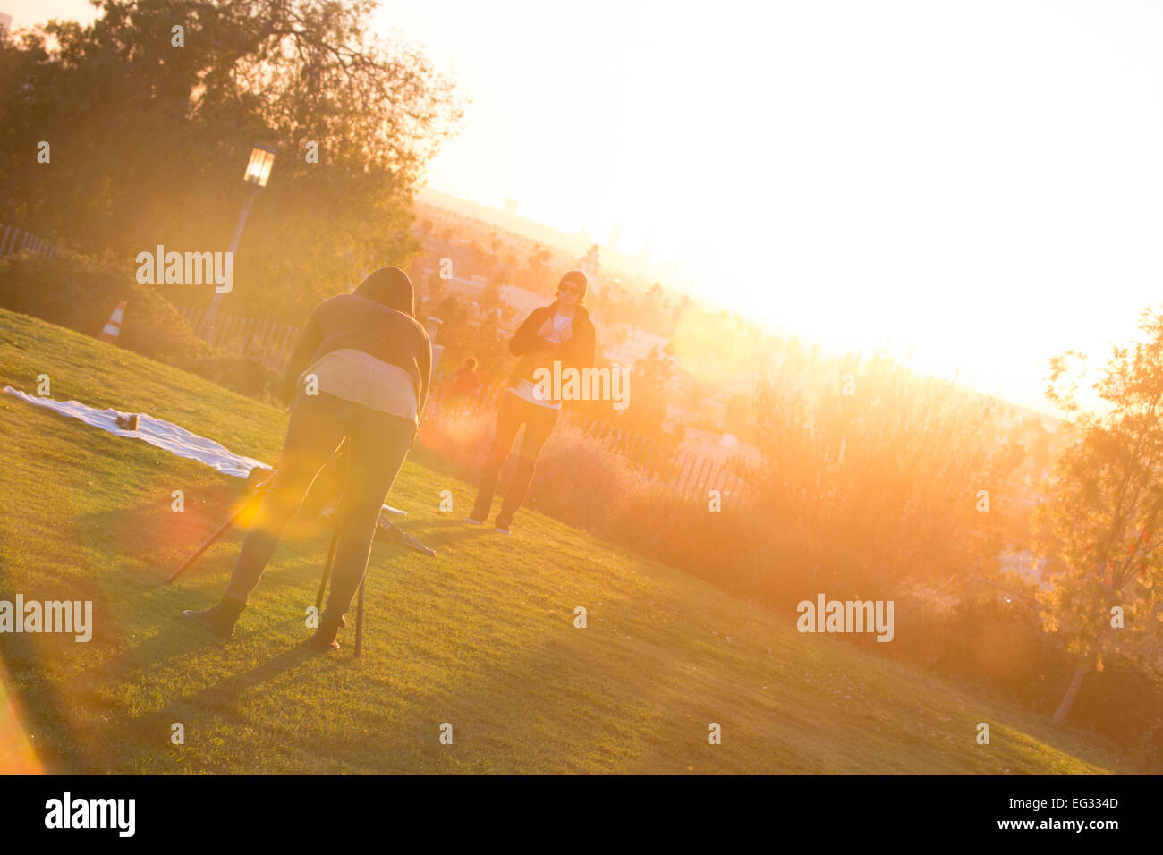 Un photographe prend une photo d'une femme au coucher du soleil Banque D'Images