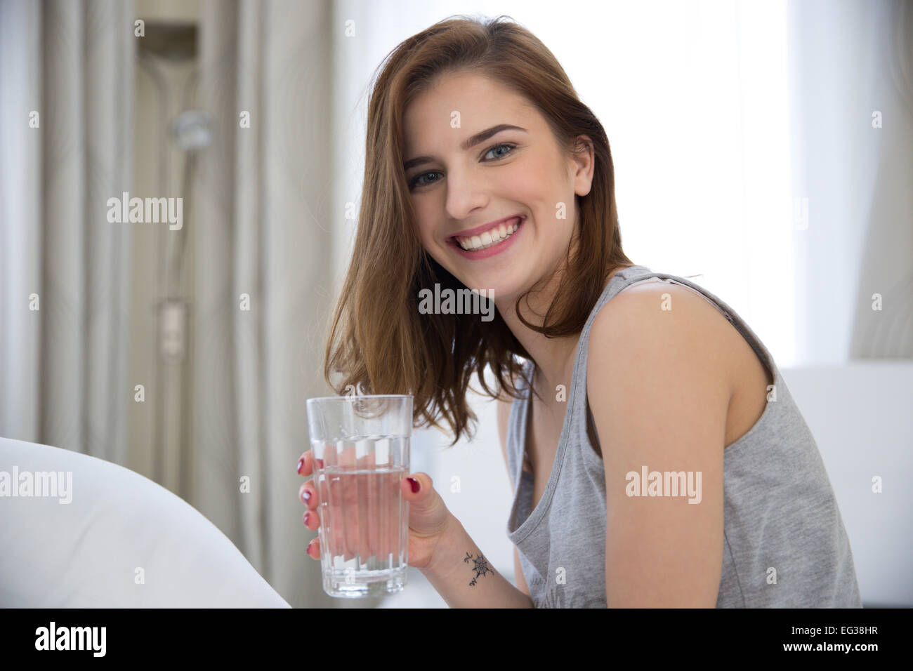 Portrait d'une femme gaie avec verre de l'eau Banque D'Images