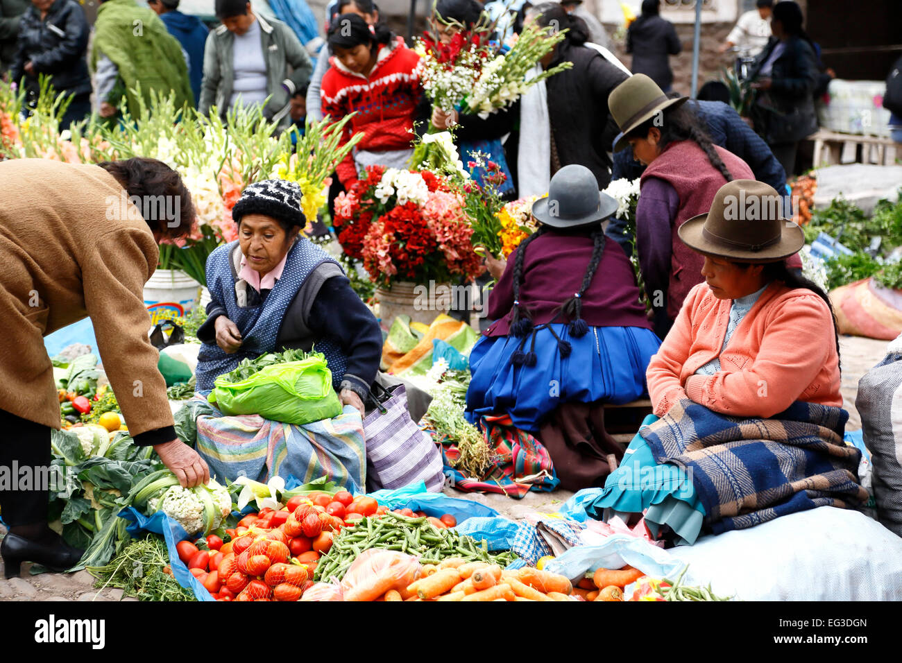 Les femmes quechua avec fournisseurs et produire des fleurs à vendre, marché de Pisac Le dimanche, Cusco, Pérou Banque D'Images