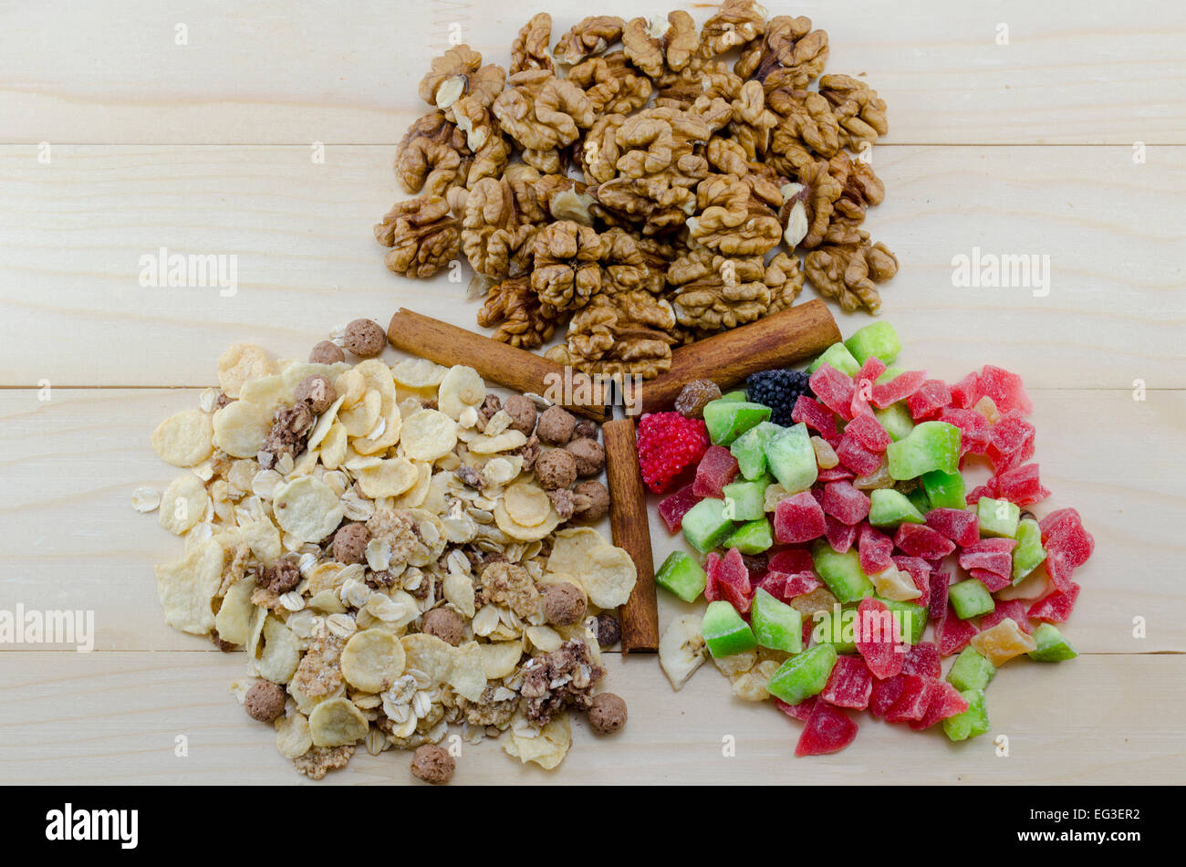 Muesli, noix et fruits secs et des bâtons de cannelle sur une table en bois Banque D'Images