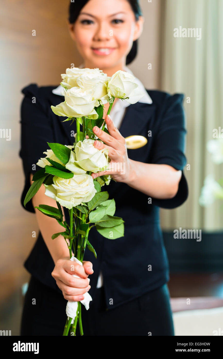 Directeur de l'hôtel ou du directeur ou superviseur bienvenue arrivant les invités VIP avec des roses à l'arrivée dans le luxe ou grand hotel Banque D'Images