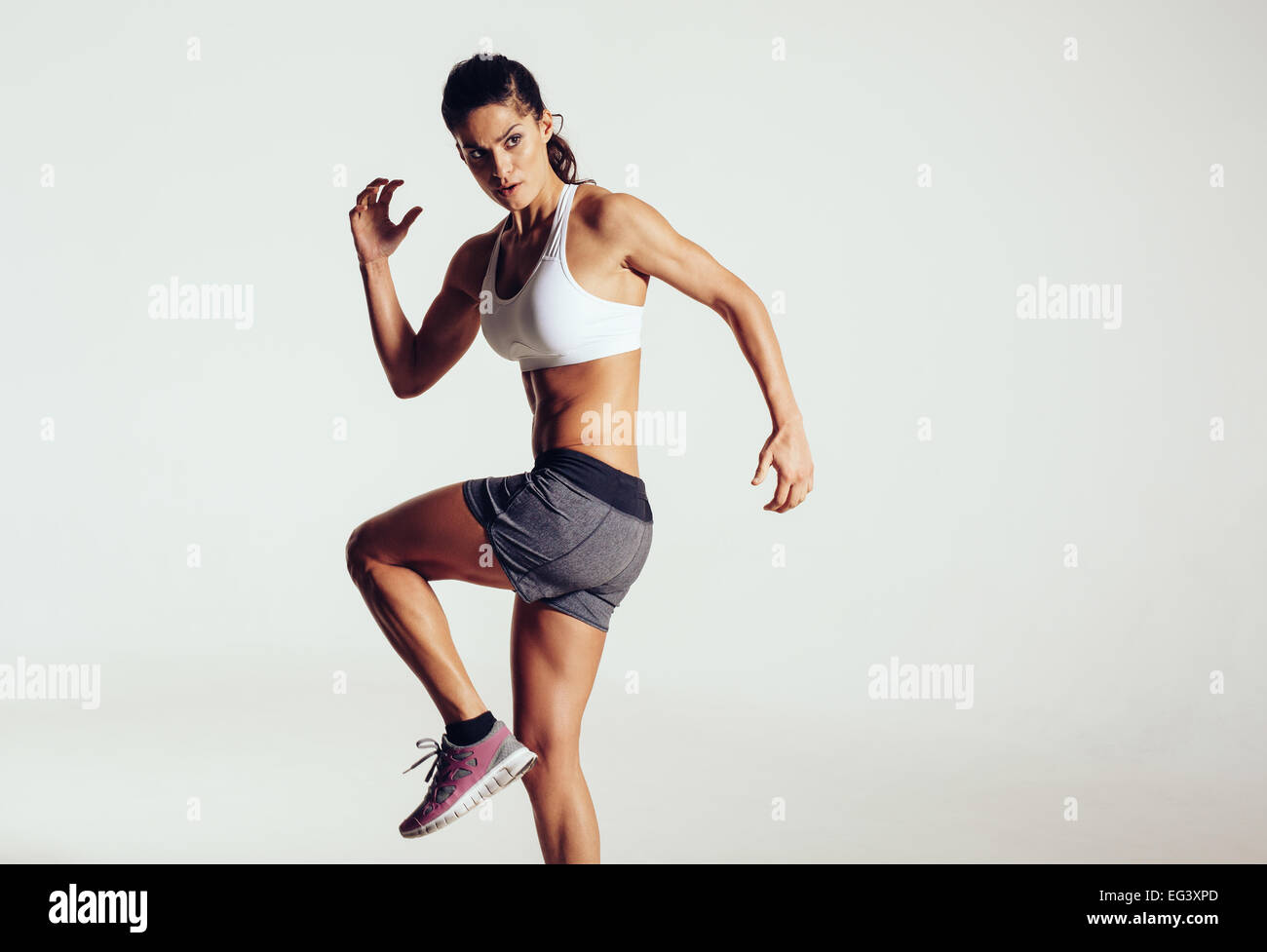 Studio shot of pretty young woman posing athlétique sur fond gris. Athlète féminin de l'exercice et à l'écart un copyspace. Banque D'Images
