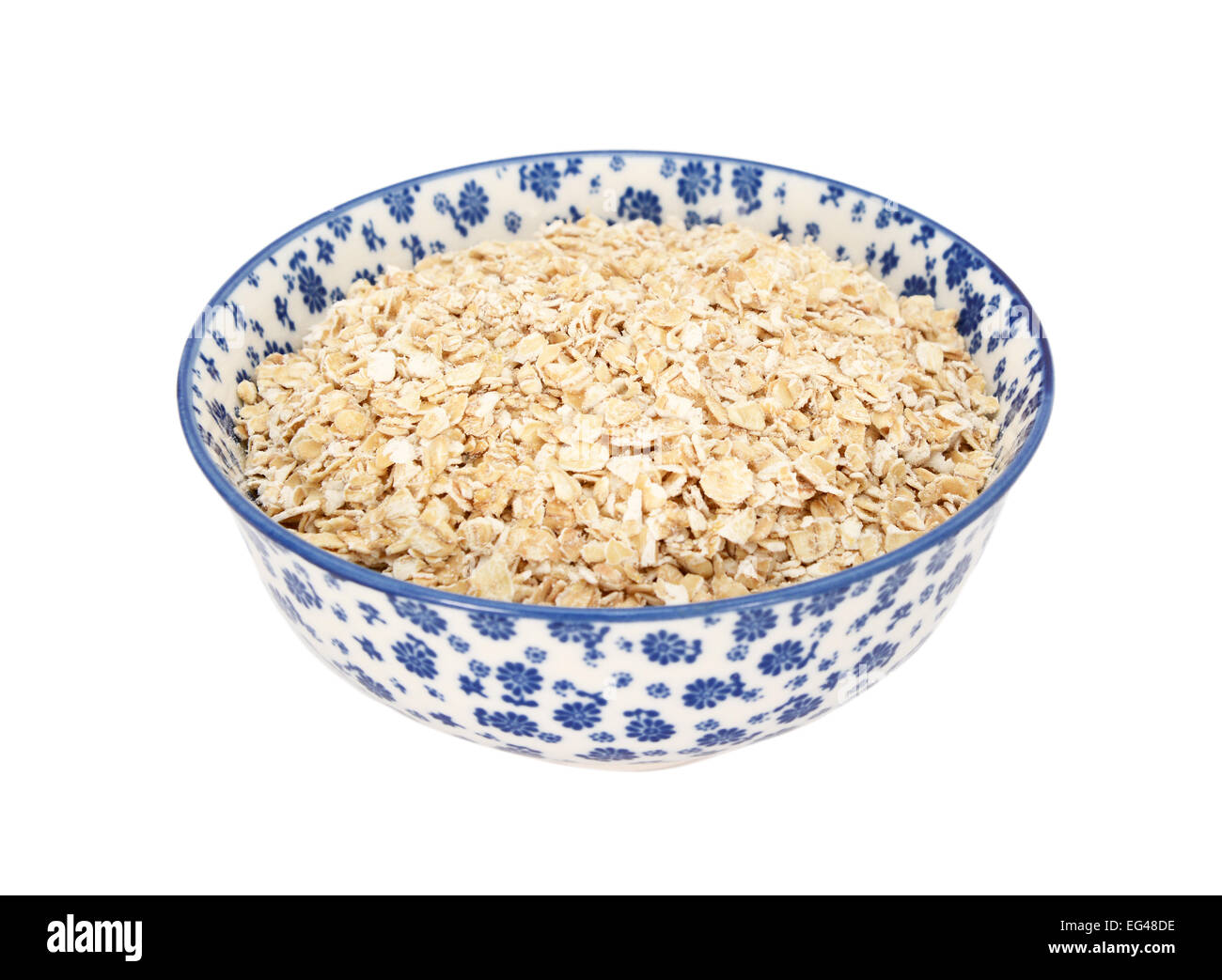 Porridge d'avoine dans un bol en porcelaine bleu et blanc avec un design floral, isolé sur fond blanc Banque D'Images