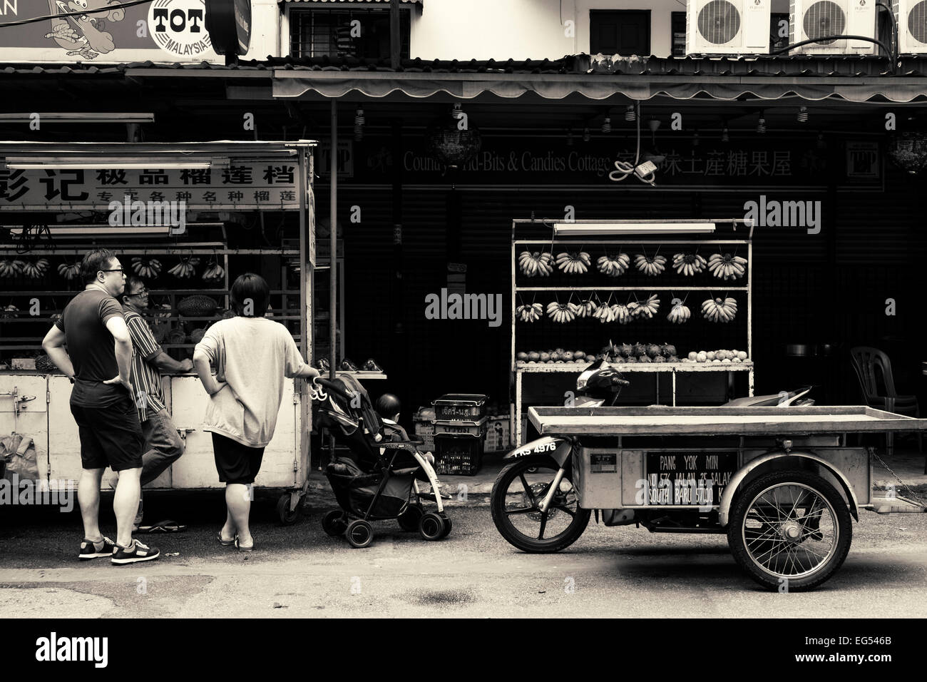 Étal de fruits et de moto dans le Jalan Alor colporteurs food street à Kuala Lumpur, Malaisie. Noir et blanc. Banque D'Images
