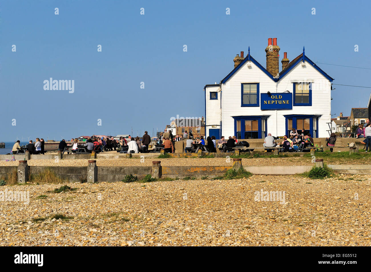 Les gens de prendre un verre au soleil dans un pub au bord de la plage le vieux neptune whitstable kent Banque D'Images