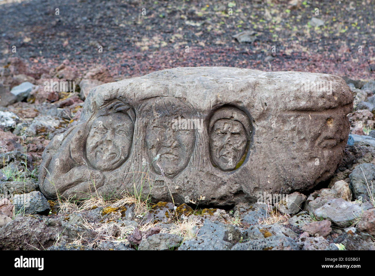 Trois visages sculptés dans une pierre dans Hofn, Islande. Banque D'Images